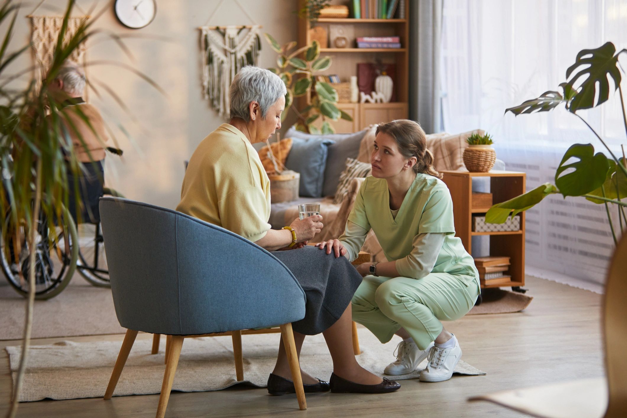 Senior woman receiving support from female caregiver at home